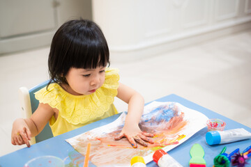 Asian toddler girl paint watercolor by her hand. - 384820705