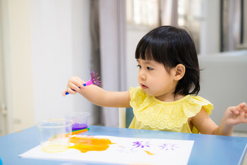 child painting with a paintbrush on the table. toddler draw watercolor. - 384821168