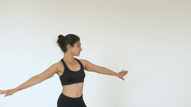 A young Indian Ballerina trains in a Gym, does a Spinning exercise, And Is dressed in a Black Top and Leggings. Sports Concept Healthy Life