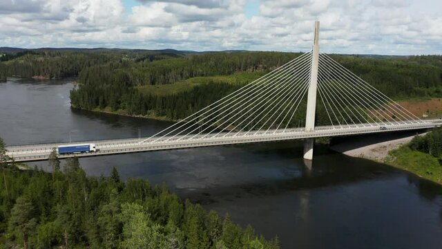 Aerial view towards a truck on the Smaalenene Bridge, at the Glomma river, sunny, summer day, in Spydeberg, Agder, Norway - tilt down, drone shot
