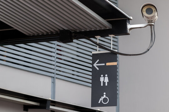 Lavatory restroom sign on black board sticked under the roof near outdoor CCTV in public toilet with copy space. - Powered by Adobe