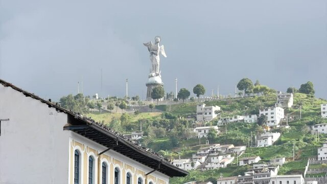 Birds soar over traditional buildings in Quito Ecuador & Epic El Panecillo "La Virgen del Panecillo" statue monument in background