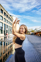 Beautiful woman dancer with long blond hair posing on city street. Female dancing improvisation - latina dance, tango, contemporary and bachata