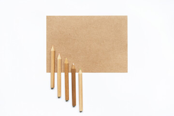 Blank mockup of creativity inspiration. Sort of pencils and recycled paper note isolated on white background. Horizontal view of set of empty piece of paper and different color pencils ready to draw. 