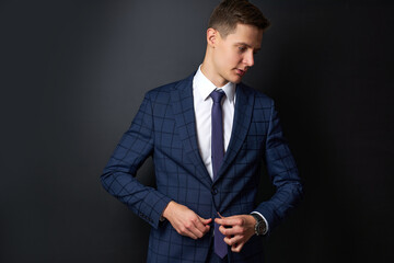 portrait of caucasian handsome male in stylish suit posing at camera, isolated over black background. business people concept. in contemplation