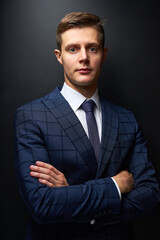 young businessman in crossed arms pose isolated over black background, man in formal suit posing