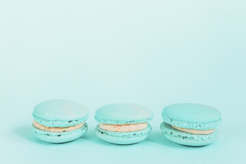 Sweet almond colorful unicorn blue macaron or macaroon dessert cake isolated on trendy blue pastel background. French sweet cookie. Minimal food bakery concept Copy space