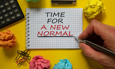 Mail hand writing 'time for a new normal' on white note, beautiful yellow background, colored paper...
