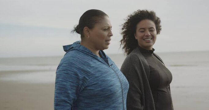 Mother and daughter plus size females exercising outdoors, Obese black women walking on beach body positive
