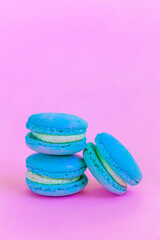 Sweet almond colorful unicorn blue macaron or macaroon dessert cake isolated on trendy pink pastel background. French sweet cookie. Minimal food bakery concept Copy space