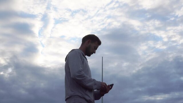A young athlete chooses a song on a smartphone before a morning jog