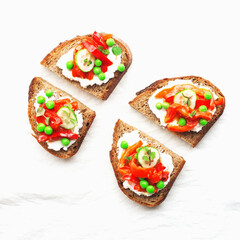 Grain bread slices for sandwiches with curd cheese, baked capsicum, green fresh peas and mint on a light background. Top view,