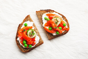 Grain bread slices for sandwiches with curd cheese, baked capsicum, green fresh peas and mint on a light background. Top view,