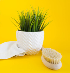 dry massage wooden brush on yellow background and white towel. eco-friendly and natural concept