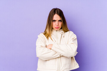 Obraz premium Young caucasian woman isolated on purple background blows cheeks, has tired expression. Facial expression concept.