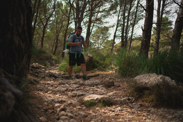 Hiker using a smartphone on a trail in Serra de Tramuntana, Mallorca