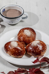 Chocolate brioches over a white table with autumn leaves