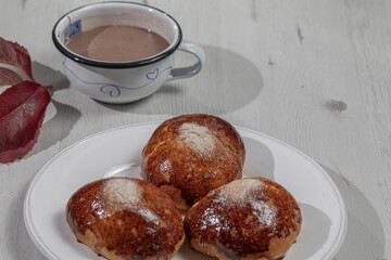 Chocolate brioches over a white table with autumn leaves
