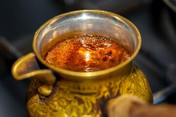 Fresh hot tasty coffee boiled in cezve, copper turk.