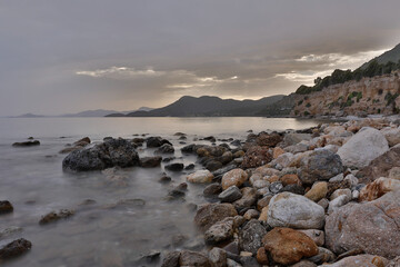 Fototapeta na wymiar Rocky stretch of coast of the Mediterranean Sea on the Greek Aegean island of Samos with a calm water surface.