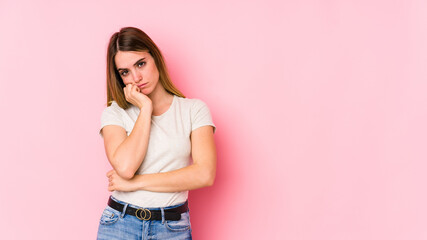 Young caucasian woman isolated on pink background tired of a repetitive task.