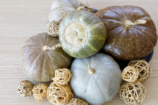 Still life with pumpinks and starw balls on a wooden table