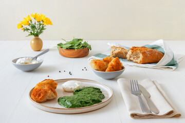 Homemade fresh creamy spinach and poached egg with roasted bread. Delicious healthy brunch or lunch. Low angle view.