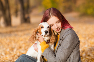 young beautiful woman playing with her dogs  in the autumn outdoor