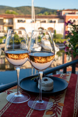 Tasting of local rose wine and soft french goat cheese in summer with sail boats haven of Port Grimaud on background, Provence, France