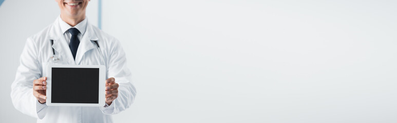 Panoramic shot of doctor holding digital tablet with blank screen