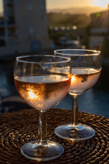 Drinking of local rose wine at sunset with sail boats haven of Port Grimaud on background, Provence, France
