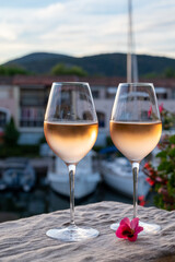 Tasting of local rose wine in summer with sail boats haven of Port Grimaud on background, Provence, France