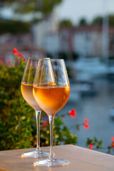 Tasting of local rose wine in summer with sail boats haven of Port Grimaud on background, Provence, France