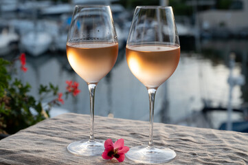 Tasting of local rose wine in summer with sail boats haven of Port Grimaud on background, Provence, France