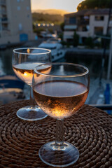 Drinking of local rose wine at sunset with sail boats haven of Port Grimaud on background, Provence, France