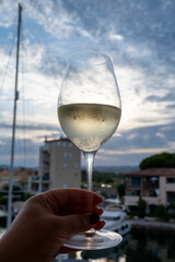 Tasting of local white wine in summer with sail boats haven of Port Grimaud on background, Provence, France