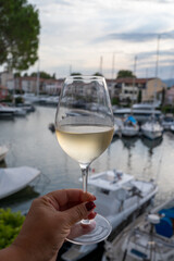 Tasting of local white wine in summer with sail boats haven of Port Grimaud on background, Provence, France
