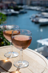 Tasting of local rose wine in summer with sail boats haven of Port Grimaud on background, Provence, France