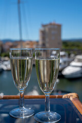 Summer party with sparkling champagne wine and sail boats haven of Port Grimaud on background, Provence, France