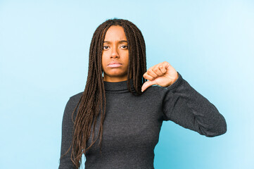 Young african american woman isolated on blue background showing a dislike gesture, thumbs down....