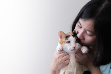 An Asian woman gently kissing a cat.This picture has space for putting description.