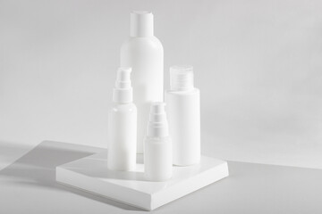 Set of white cosmetic bottles and jars with hard shadows. Home and beauty salon care concept