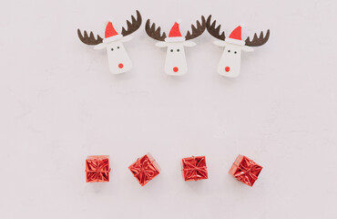 Cute and funny christmas deers with little red presents on white background. New year celebration, gift card. 