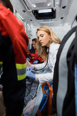 Selective focus of doctor examining patient with stethoscope near paramedics in ambulance car © LIGHTFIELD STUDIOS