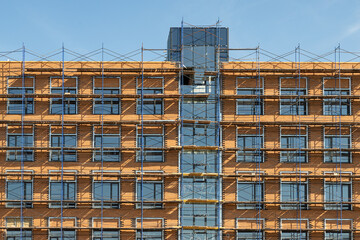 The building is under construction. Finishing the building using scaffolding. Construction background.