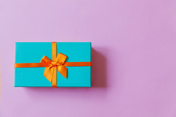 Christmas New Year birthday valentine celebration present romantic concept. Simply minimal design blue gift box isolated on violet purple colorful background. Flat lay top view, copy space