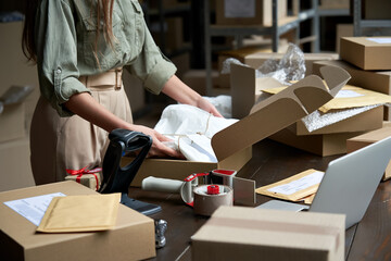 Closeup view of female online store small business owner seller entrepreneur packing package post...