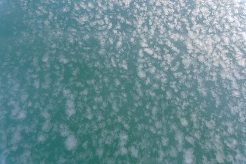 The sky is the color of sea waves and many small clouds