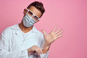 doctor in medical gloves with face mask on pink background cropped view