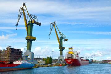 Shipyards and docks with cranes and other heavy machinery near in industrial part of old town Gdansk, Baltic coast, Gdansk bay, Poland, Europe.